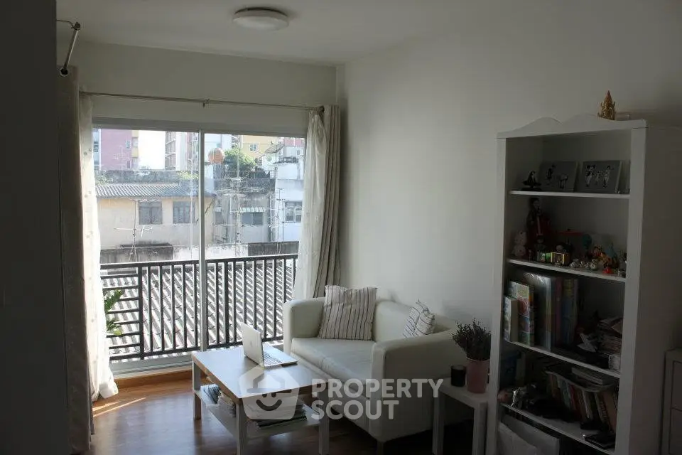 Bright living room with large window and cozy seating area, perfect for relaxation.