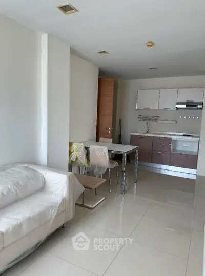 Modern open-plan living room with sleek kitchen and cozy seating area.