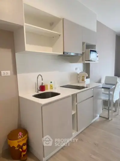 Modern compact kitchen with sleek cabinets and built-in appliances in a stylish apartment