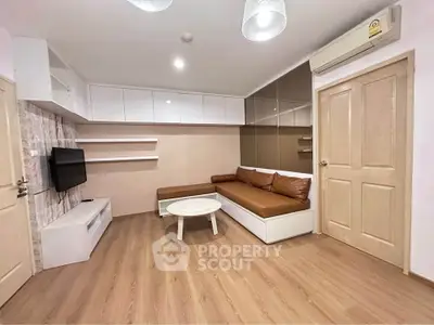 Modern living room with sleek design, featuring a cozy sectional sofa, wall-mounted TV, and stylish wood flooring.