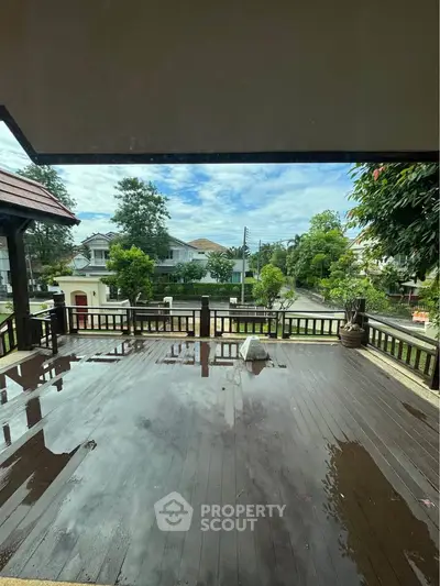 Spacious wooden balcony with scenic neighborhood view, perfect for relaxation and outdoor gatherings.