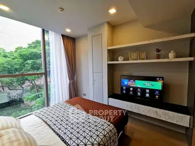 Modern bedroom with large window and built-in TV, featuring stylish decor and natural light.