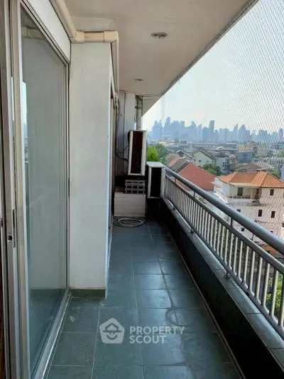 Spacious balcony with city skyline view, perfect for relaxation and enjoying urban scenery.