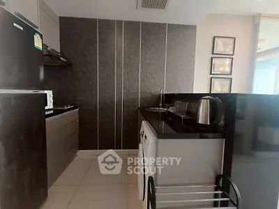 Modern kitchen with sleek black countertops and integrated appliances in a stylish apartment.