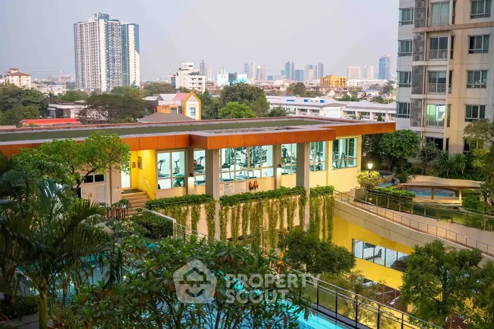 Stunning urban apartment complex with lush greenery and city skyline view