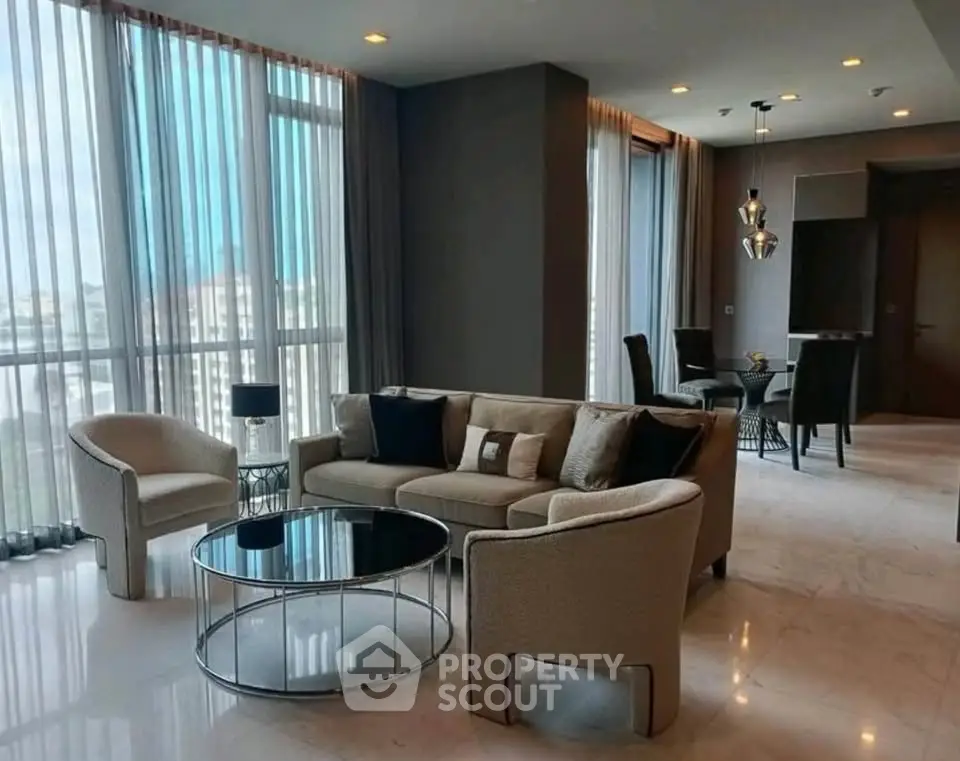 Luxurious modern living room with elegant furniture and floor-to-ceiling windows offering stunning city views.