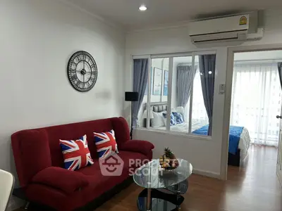 Modern living room with red sofa and stylish decor adjacent to a cozy bedroom.