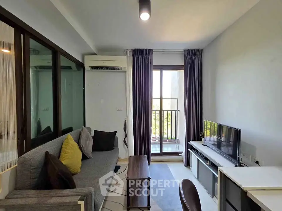 Modern living room with balcony access and stylish decor in urban apartment.