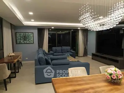 Luxurious modern living room with elegant chandelier and plush blue sofas