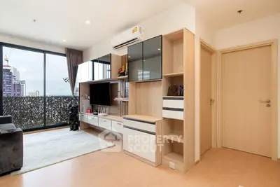 Modern living room with sleek built-in storage and large window offering city view.