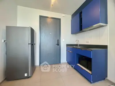 Modern kitchen with sleek blue cabinets and stainless steel fridge