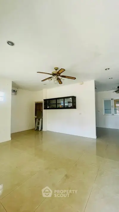 Spacious living room with ceiling fan and tiled flooring
