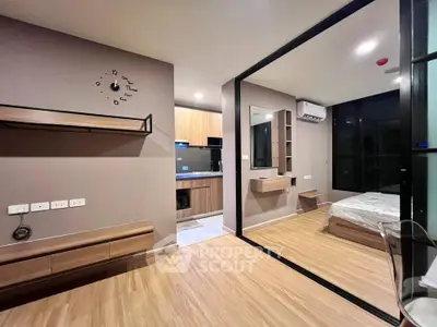 Modern studio apartment with open layout, featuring a sleek kitchen and cozy bedroom area.