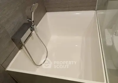 Modern bathroom with sleek bathtub and shower fixture