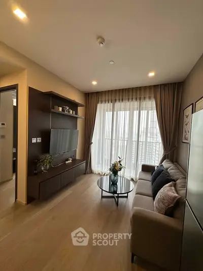 Modern living room with elegant decor and large windows offering natural light.
