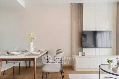 Modern living room with stylish dining area and wall-mounted TV, featuring elegant decor and wooden flooring.
