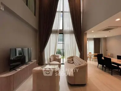 Luxurious high-ceiling living room with elegant furniture and large windows