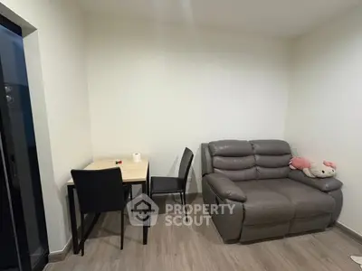 Cozy living room with modern sofa and dining table, perfect for small apartments.