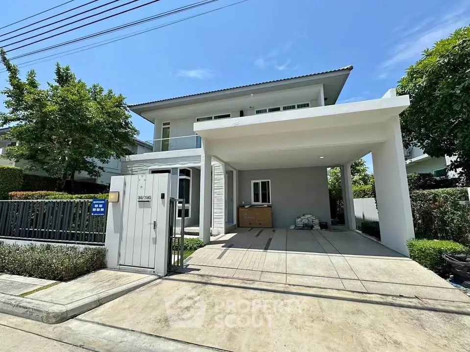 Modern two-story house with spacious driveway and lush greenery in a serene neighborhood.