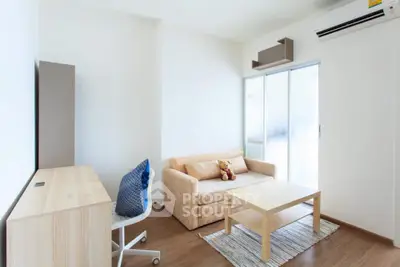 Bright and airy living room with modern furniture, large windows, and a cozy beige sofa, perfect for comfortable urban living.
