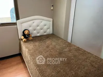 Cozy bedroom with single bed and plush teddy bear, perfect for a child's room.