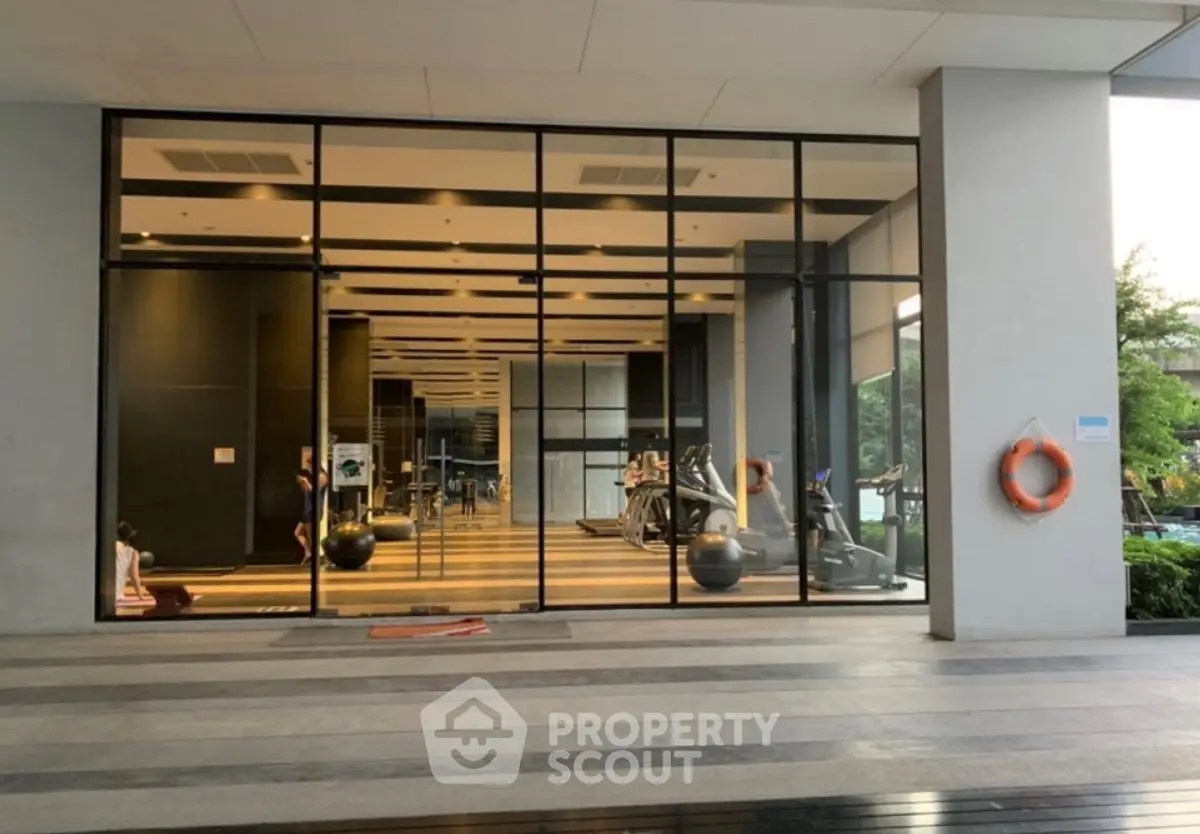 Modern gym with large glass windows in a luxury residential building.