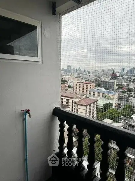 High-rise balcony with cityscape view and safety netting, perfect for urban living.