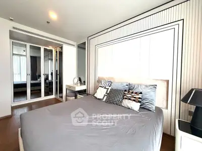 Modern bedroom with stylish decor and mirrored wardrobe in a contemporary apartment.
