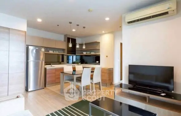 Modern open-plan living room with kitchen, dining area, and sleek appliances.