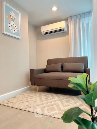 Cozy living room with modern sofa and air conditioning, perfect for relaxation.