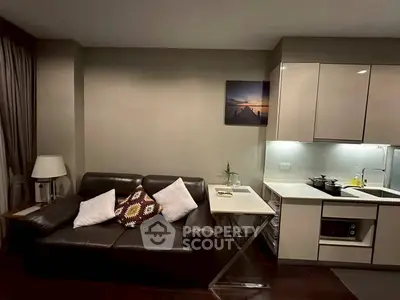 Modern living room with sleek kitchen, leather sofa, and stylish decor