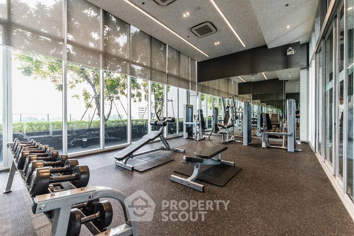 Spacious modern gym with state-of-the-art equipment and large windows offering garden views.