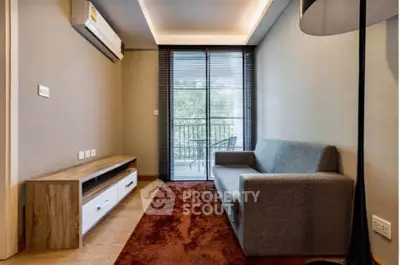 Cozy living room with modern sofa and balcony view, perfect for relaxation.