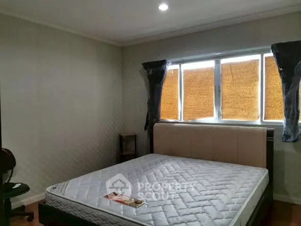 Spacious bedroom with large window and comfortable bed in a cozy setting.