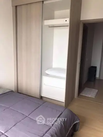 Modern bedroom with built-in wardrobe and cozy bedding in a stylish apartment.