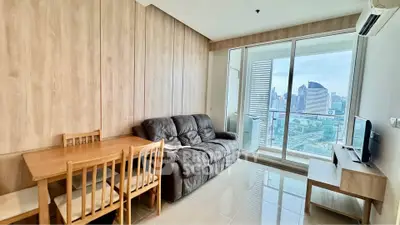 Modern living room with city view, featuring cozy seating and dining area.