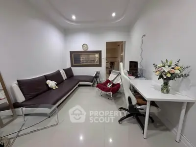 Modern living room with sleek furniture and home office setup, perfect for urban living.