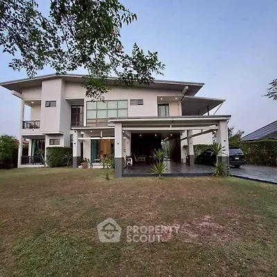 Modern two-story house with spacious lawn and carport, showcasing contemporary architecture.