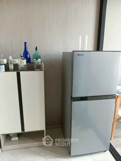 Modern kitchen with sleek refrigerator and stylish cabinetry, perfect for contemporary living.