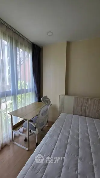 Cozy bedroom with large window and study desk, perfect for natural light lovers.