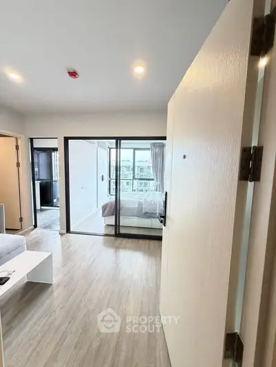 Modern apartment entrance with open living space and bedroom view