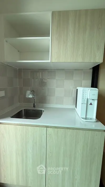 Modern compact kitchen with sleek cabinetry and built-in sink, perfect for urban living.