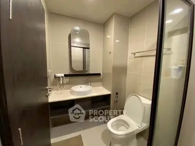 Modern bathroom with sleek design, featuring a large mirror, stylish sink, and contemporary fixtures.