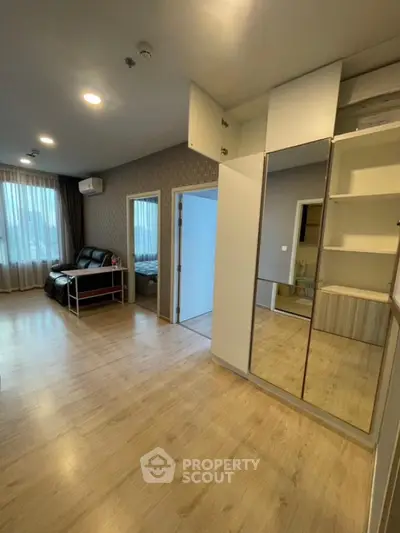 Spacious modern living room with wooden flooring and ample natural light