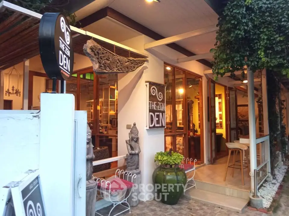 Charming exterior of The Zen Den with inviting decor and lush greenery.