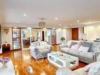 Spacious and elegant living room with plush sofas and wooden flooring.