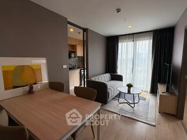 Modern living room with stylish decor and open kitchen in a cozy apartment.