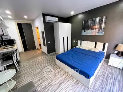 Modern studio apartment with sleek design, featuring a cozy bed, compact kitchen, and stylish decor.