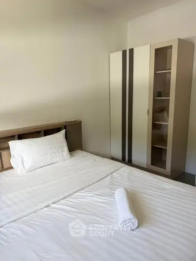 Cozy bedroom with modern wardrobe and neatly made bed, perfect for restful nights.