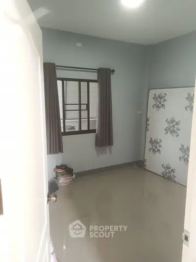 Cozy bedroom with tiled floor and floral mattress, perfect for minimalist living.